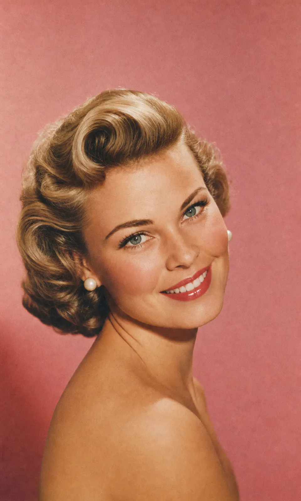 A model with a sculpted hairstyle in a 1950s-inspired salon portrait.